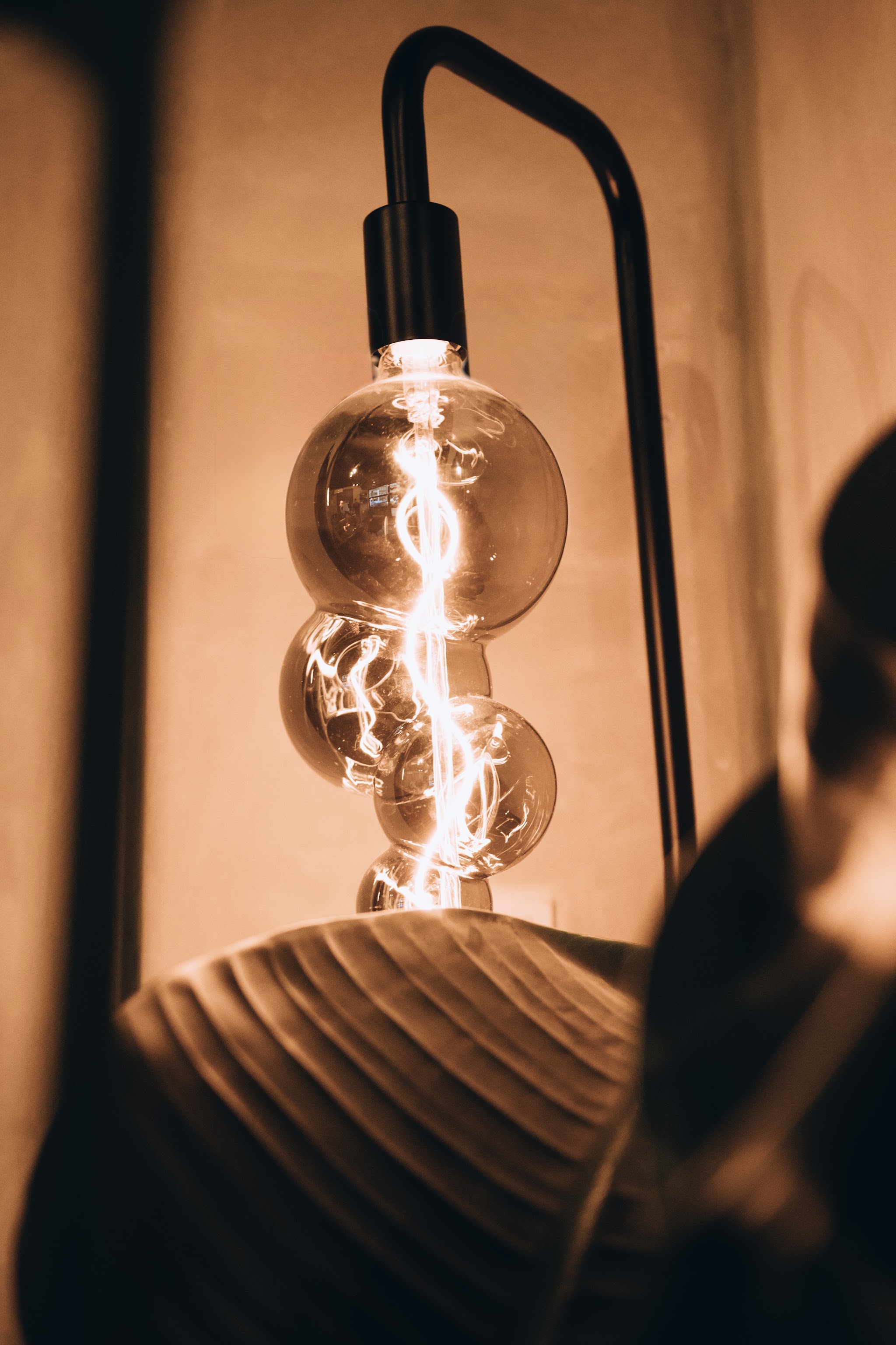 Een gloeilamp met warm licht naast de stoel