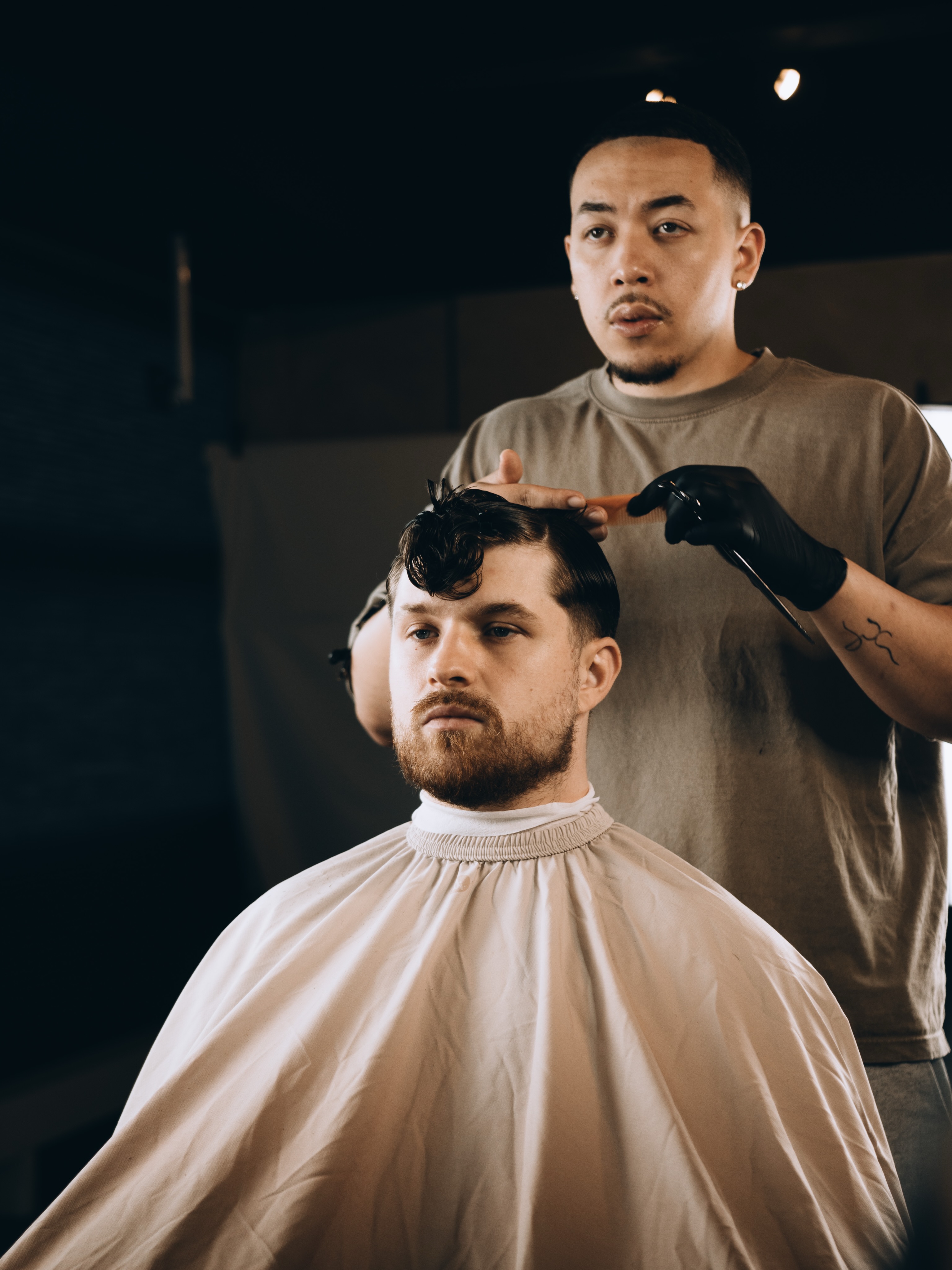Gio aan het werk: hij knipt een klant in de stoel bij The Wave