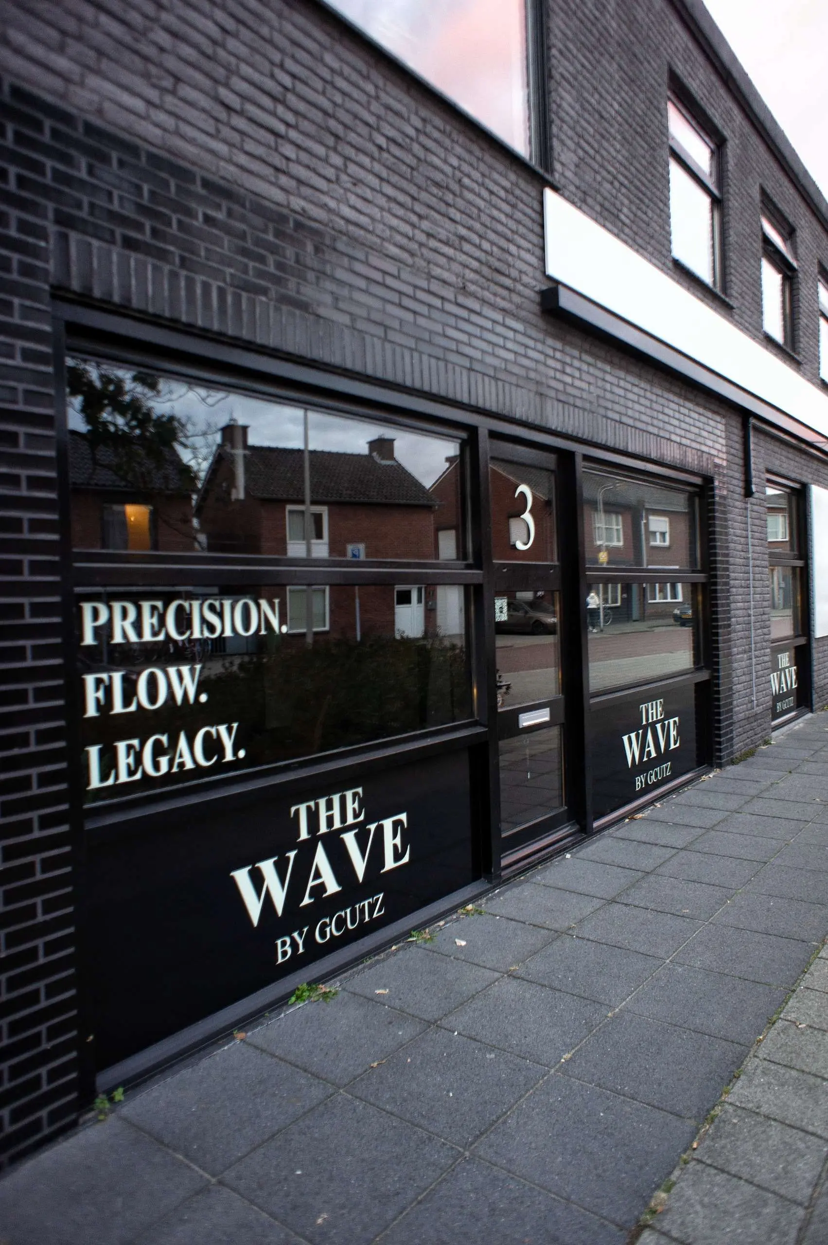De pui aan de Spelbergsweg 3 met de belettering Precision. Flow. Legacy. en The Wave by Gcutz op het glas